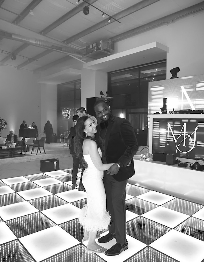 The bride and groom dance on the light up dance floor. 