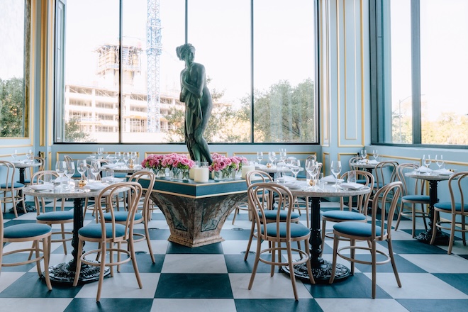 Checkered black and white floors and panoramic windows detail the dining room at Annabelle Brasserie. 