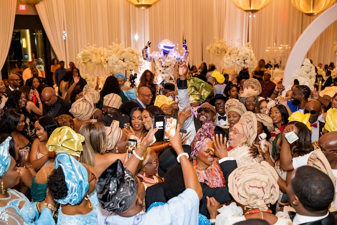 Guests gather and dance on the dance floor at the reception.