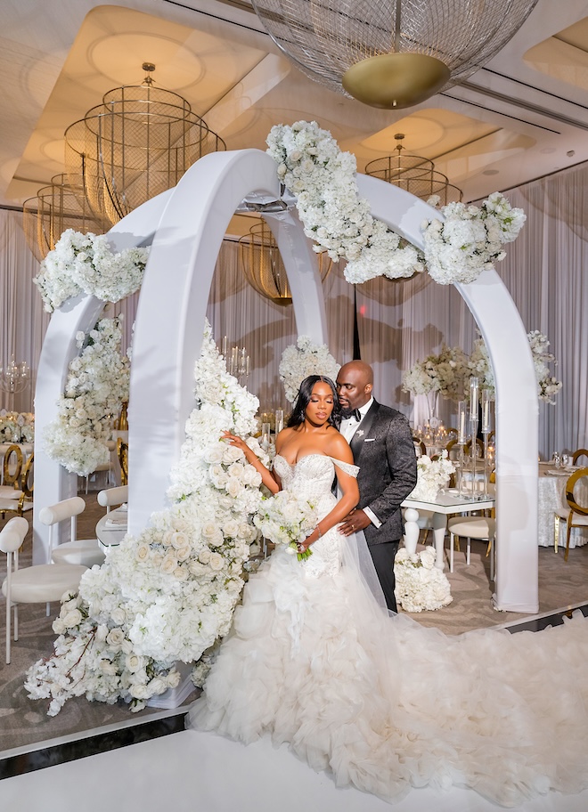 The bride and groom stand under a canopy at their wedding reception at Thompson Houston. 