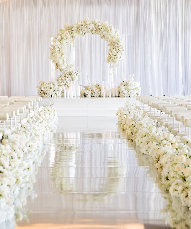 White florals adorn the all-white wedding ceremony at Thompson Houston. 