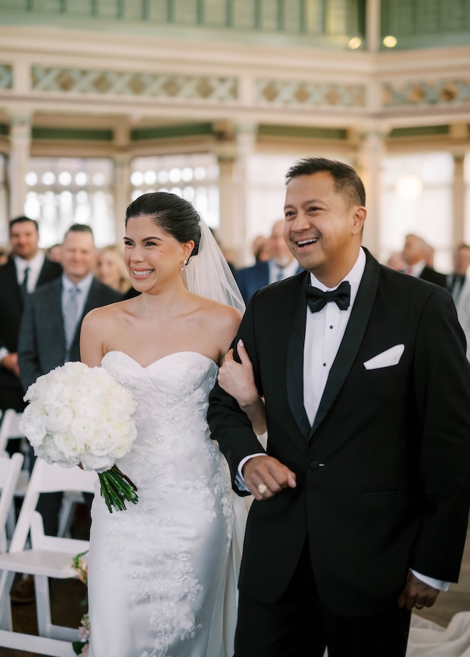 The father of the bride walks his daughter down the aisle. 