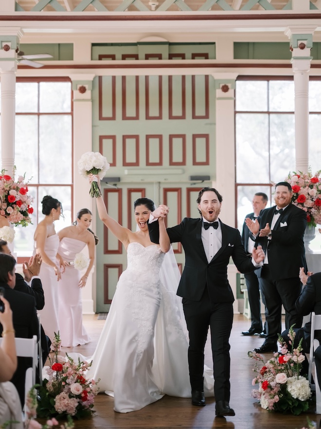 The bride and groom celebrate as the walk down the aisle after saying "I do." 