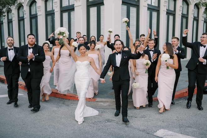The bride and groom and their wedding party celebrate outside of The Tremont House. 