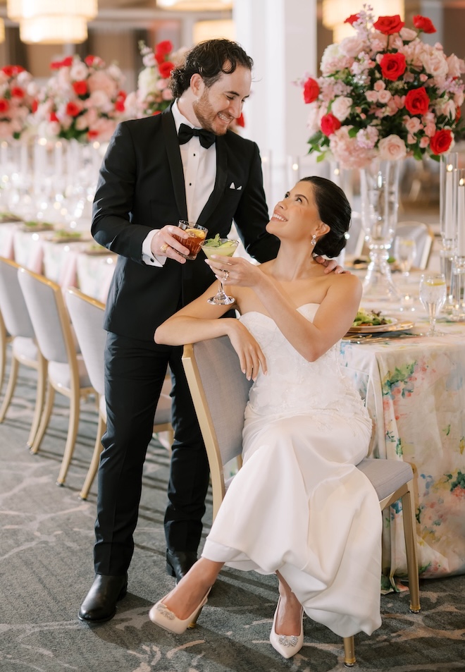 The bride and groom cheers with their signature cocktails at their wedding reception. 