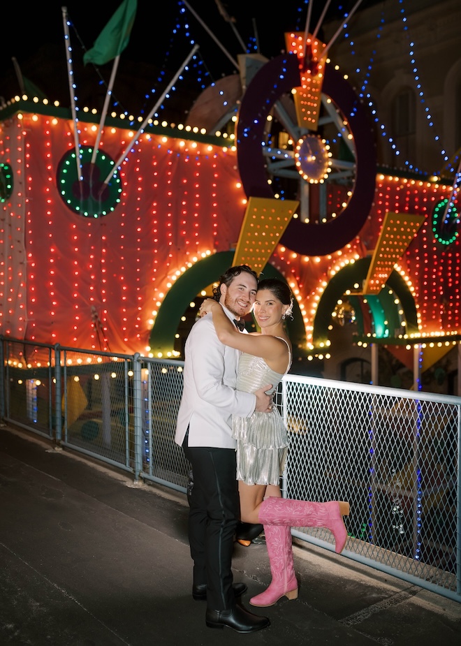 The couple stand on the balcony of The Tremont House in front of the Mardi Gras arch. 