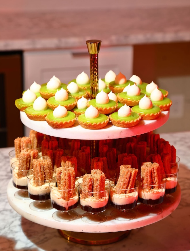 Mini desserts are placed on a cake tier at the wedding reception. 