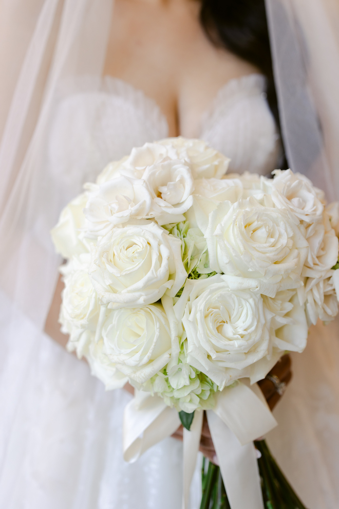 Close up of bride's white bouquet with light green accents.