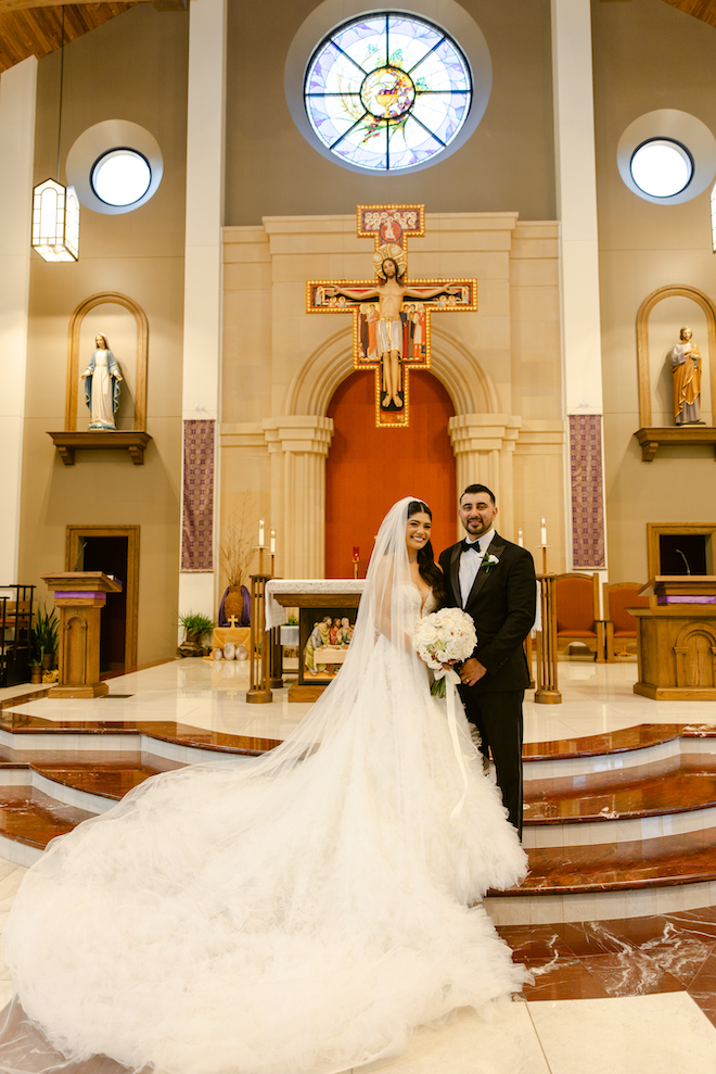 Newlyweds standing at the stunning church altar for garden-inspired wedding.