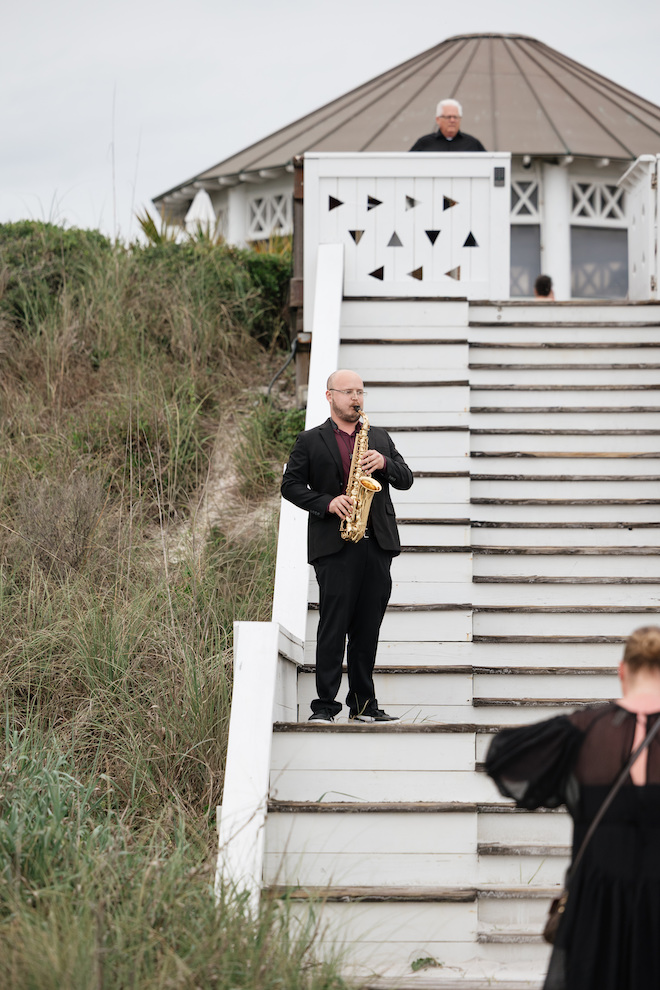 Saxophone player on the stairs leading up to the boardwalk.