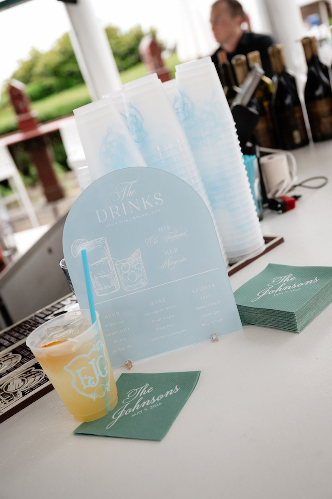 Light blue with white writing at the bar with monogrammed cups and green napkins that read, "The Johnsons".