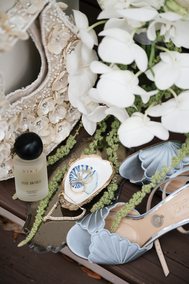 Close up of the rings in a seashell case and blue seashell patterned heels.