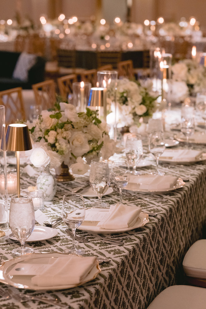Close up of reception table details with tiny lamps and green, gold, and white details.