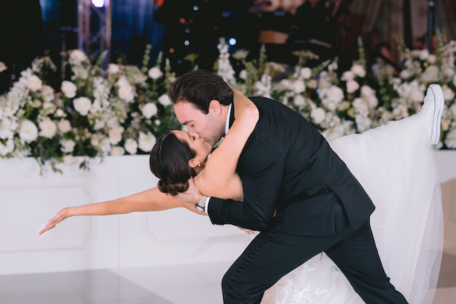Groom dipping the bride and kissing on the dance floor.