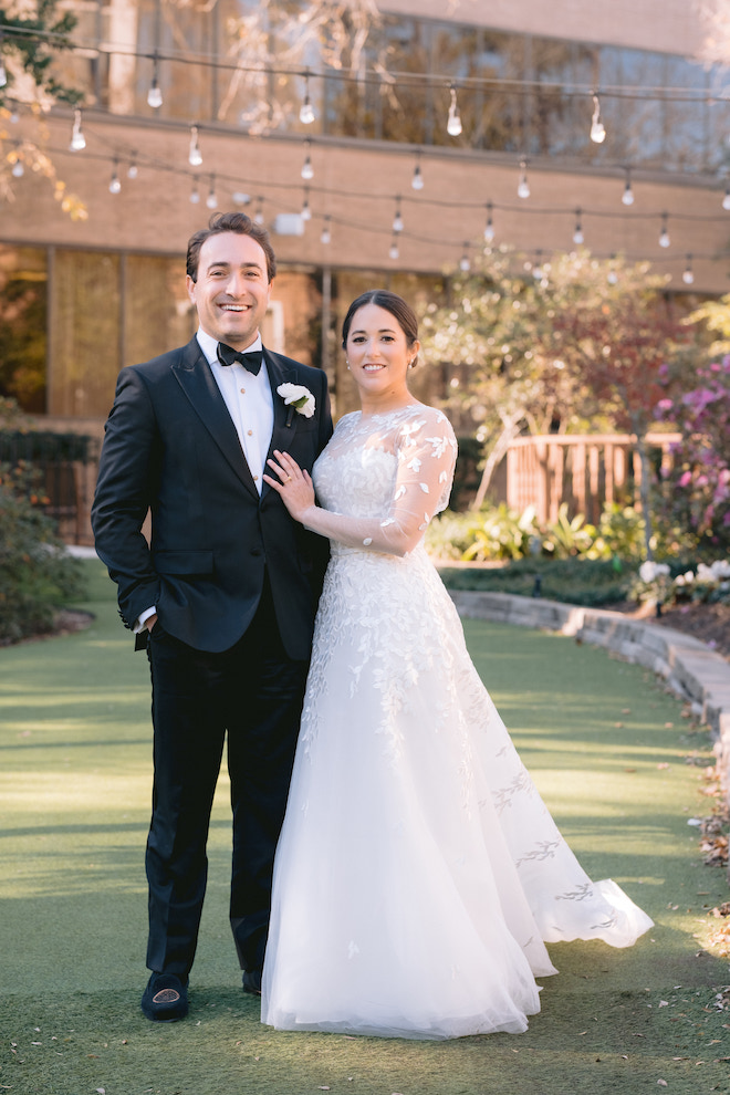 Bride and groom standing outside of venue for their outdoor Houstonian wedding.