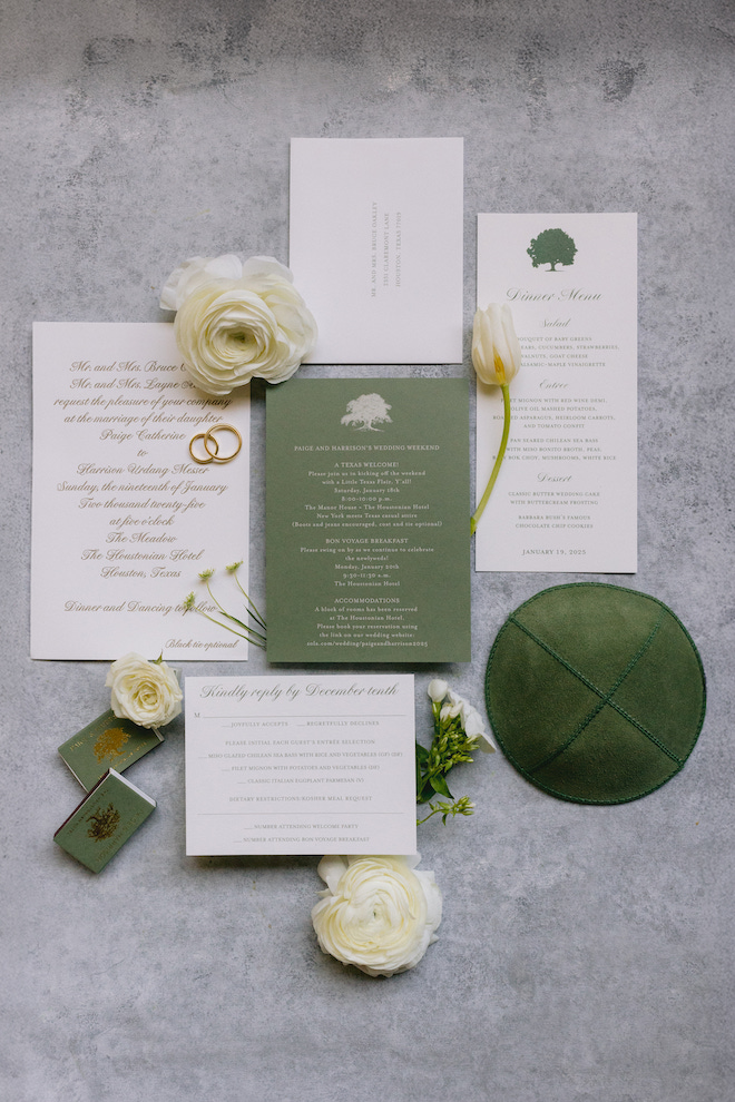 Green and white wedding invitations with white roses surrounding and a green yamaka hat.