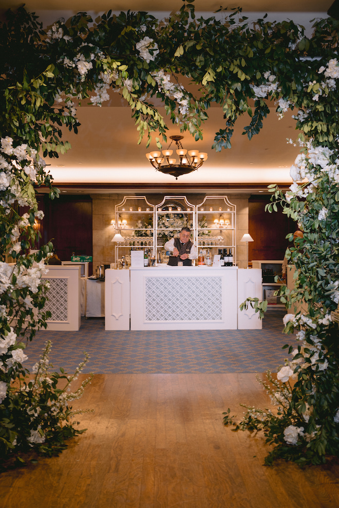 Floral arch as an entrance to wedding bar.