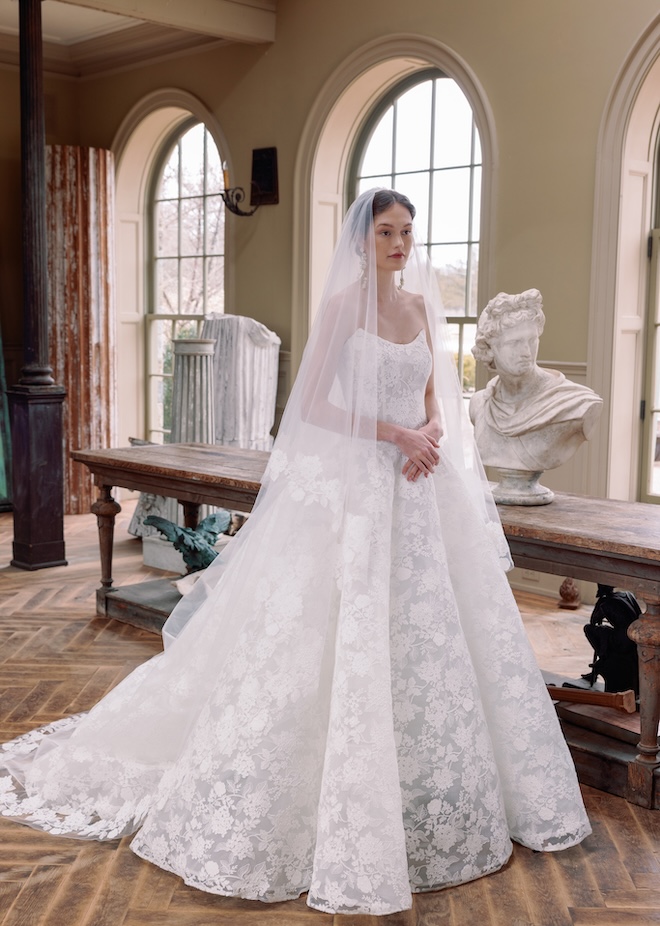 The bride wears a lace designer wedding gown and a veil.