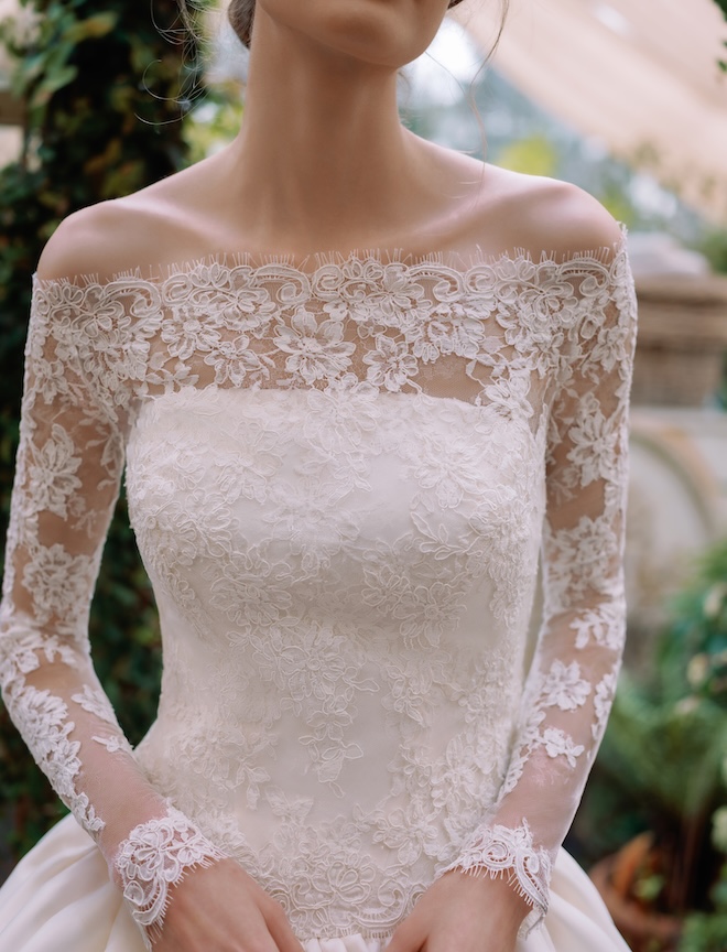 The model wears lace sleeves over her wedding gown. 