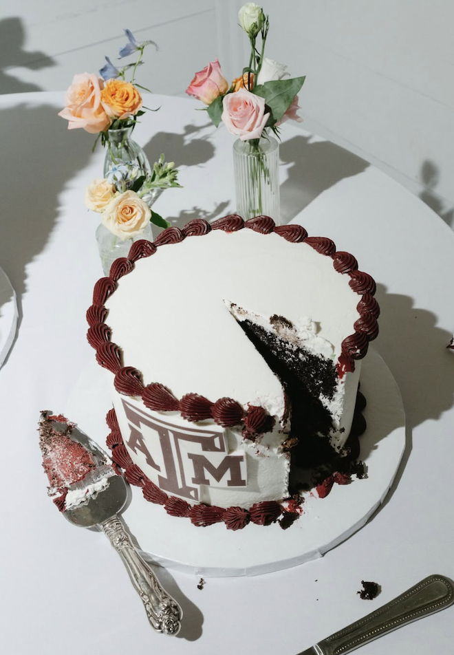 White one-tier a&m cake with maroon trimming.