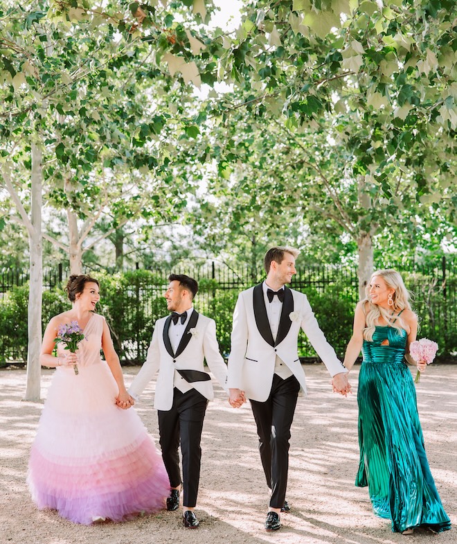 The two groom's hold hands with their best womans. 