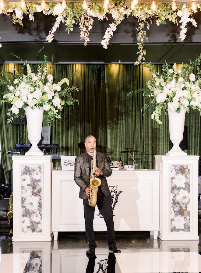A saxophonist plays at the emerald green wedding reception. 
