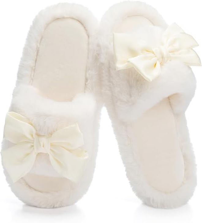 White fuzzy open-toed slippers with cute bows.