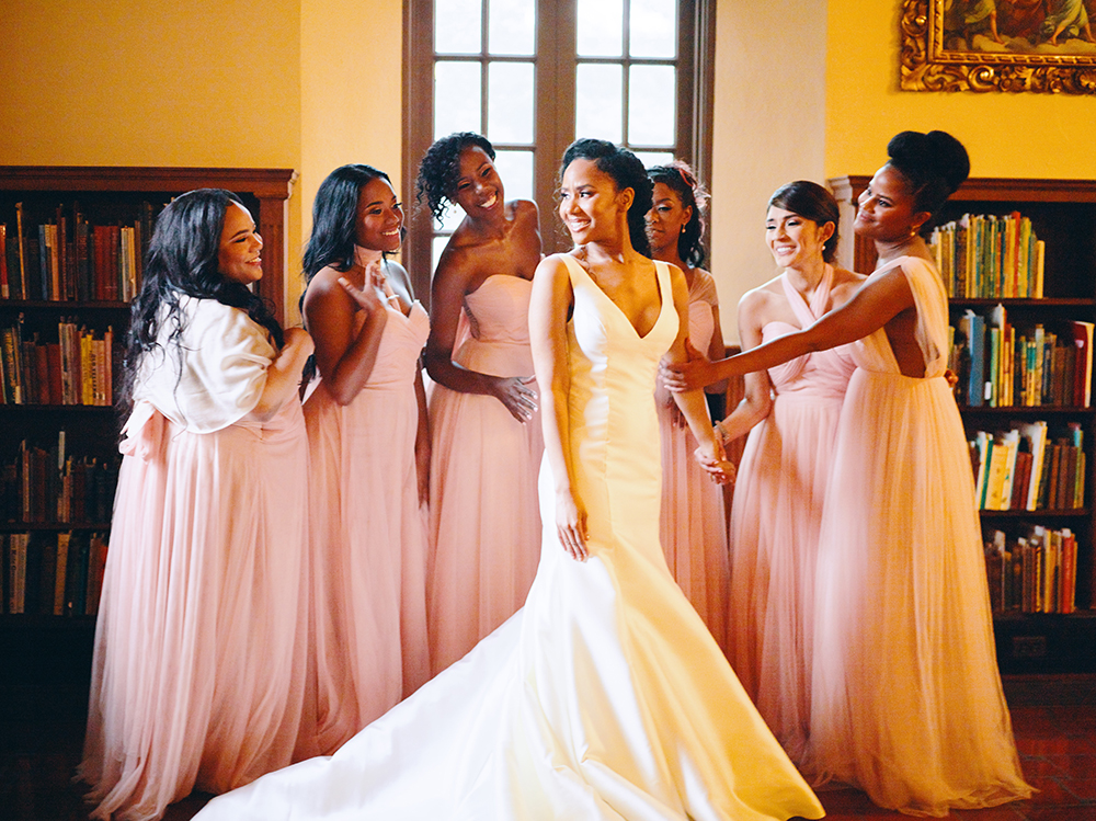 photo of bridal party with blush bridesmaids dresses and bride in sleeveless wedding gown 