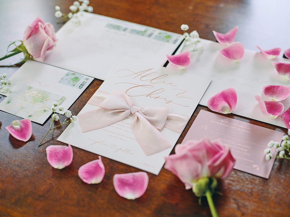 wedding invitation flat lay - bow, flower petals, blush details